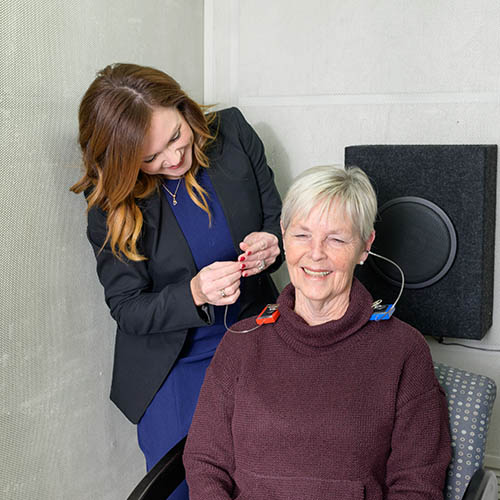 Dr. Person, Audiologist fitting tinnitus hearing aids to a ptient